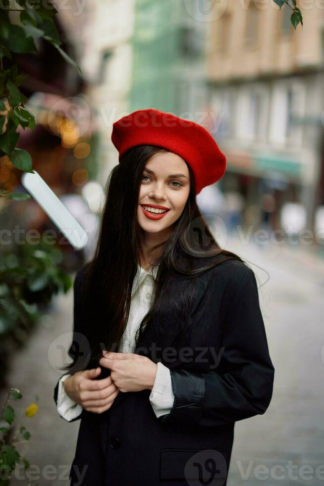 mulher sorrir moda modelo anda em em a rua dentro a cidade Centro entre a multidão dentro uma Jaqueta e vermelho boina e jeans, cinematográfico francês moda estilo roupas, viagem para Istambul Primavera foto