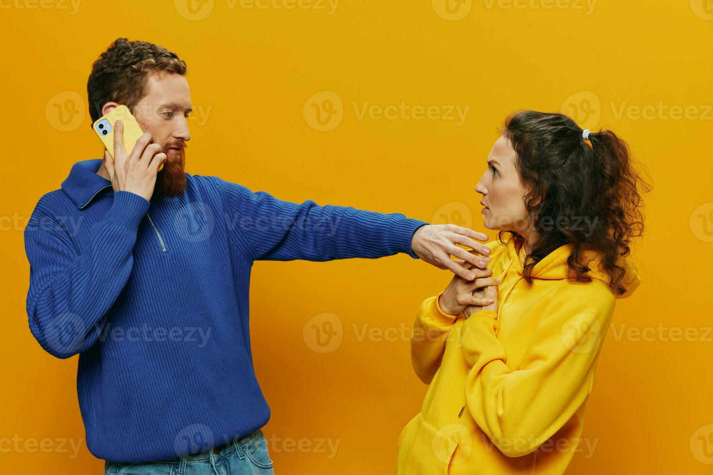 mulher homem alegre casal com telefones dentro mão social trabalho em rede e comunicação torto sorrir Diversão e lutar, dentro amarelo fundo. a conceito do real família relacionamentos, freelancers, trabalhos on-line. foto