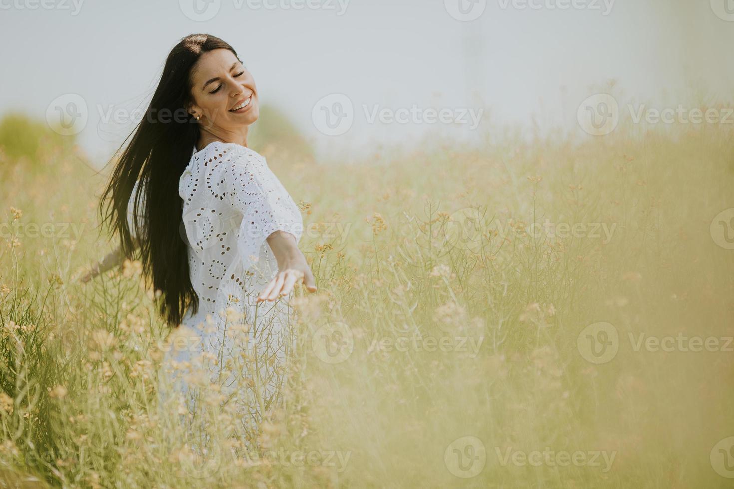 jovem no campo de colza foto