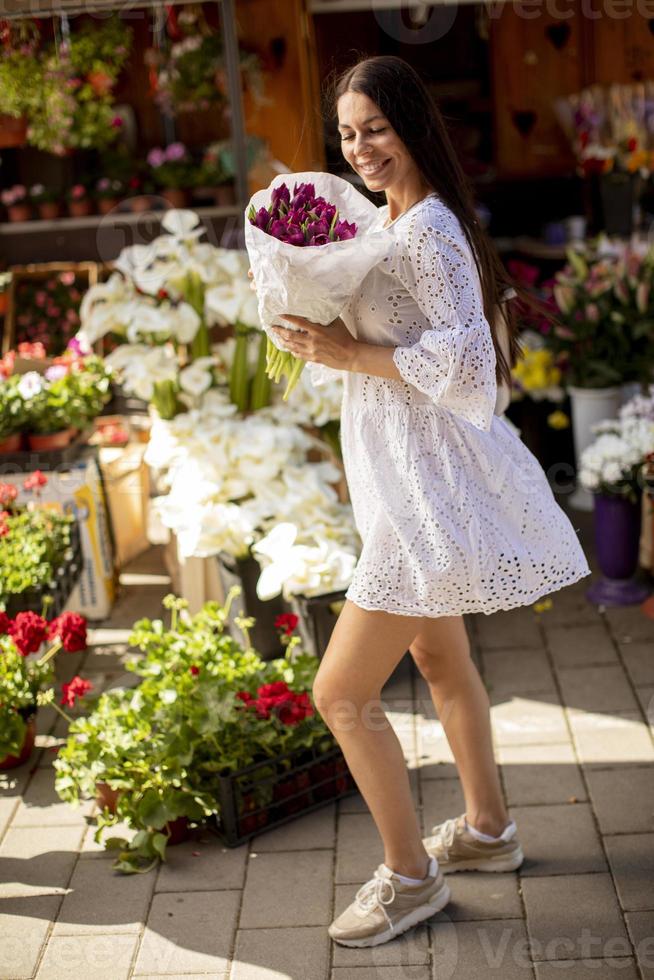 jovem comprando flores no mercado de flores foto