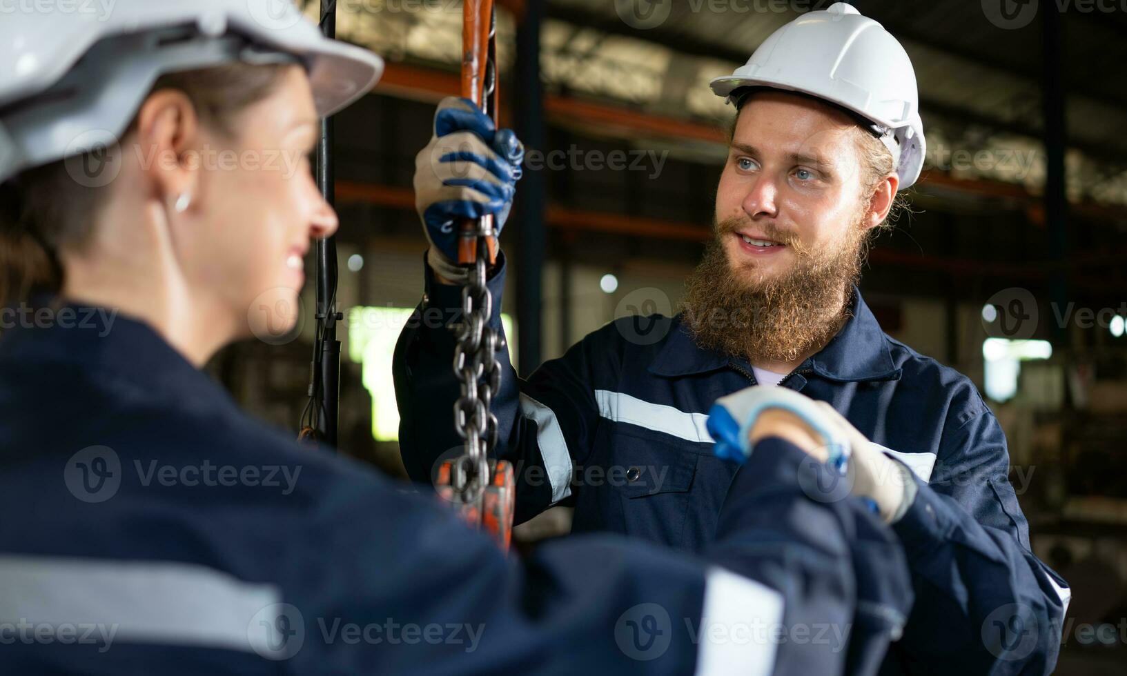 dois técnicos inspecionando e testando o funcionamento de guindastes de elevação em plantas industriais pesadas. foto