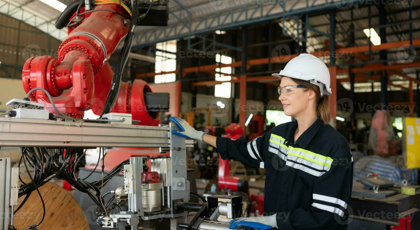 fêmea elétrico engenheiro com a missão do instalando uma robô braço elétrico sistema foto
