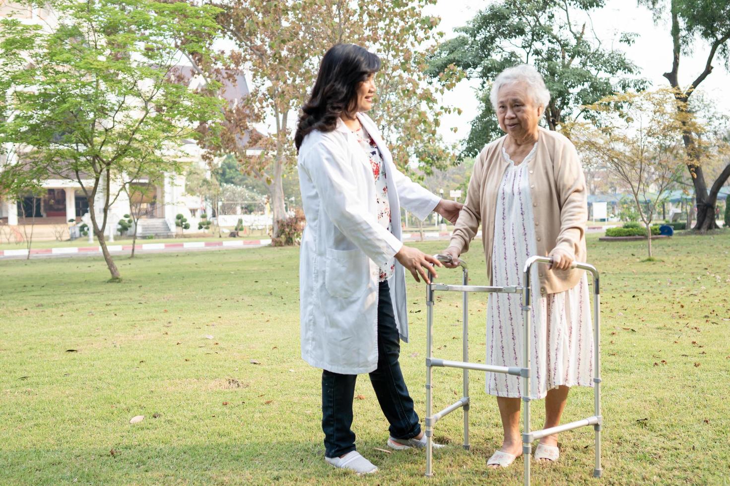 médico ajuda e cuidados idosos idosas asiáticas usam andador com forte saúde ao caminhar no parque foto