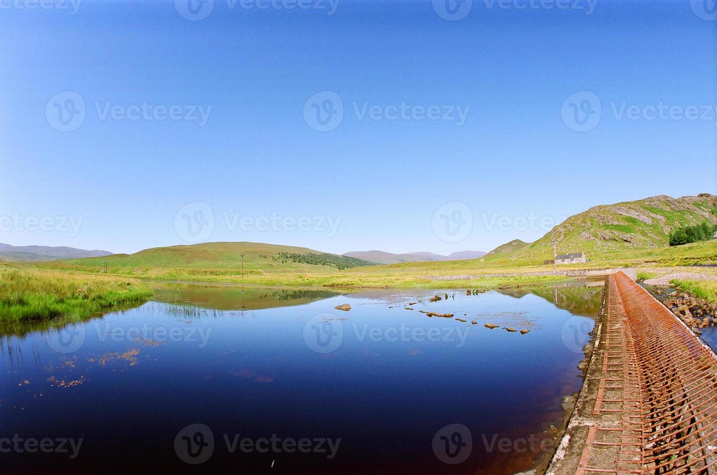 água azul com colinas verdes foto