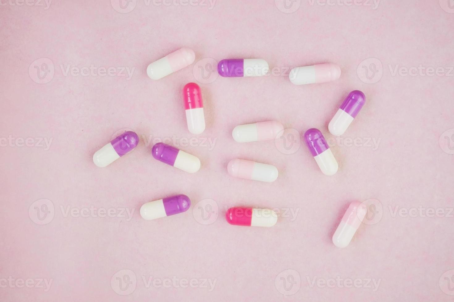 uma macro detalhada de comprimidos e cápsulas com fundo rosa foto