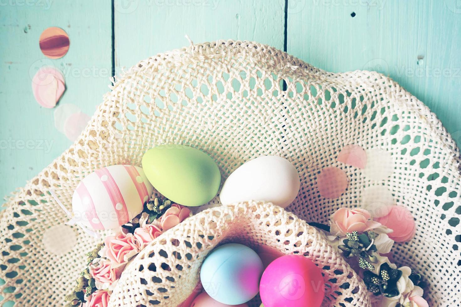 um lindo e colorido apartamento em close-up de ovos de páscoa em tons pastéis e listrado em uma cesta com flores e espaço foto