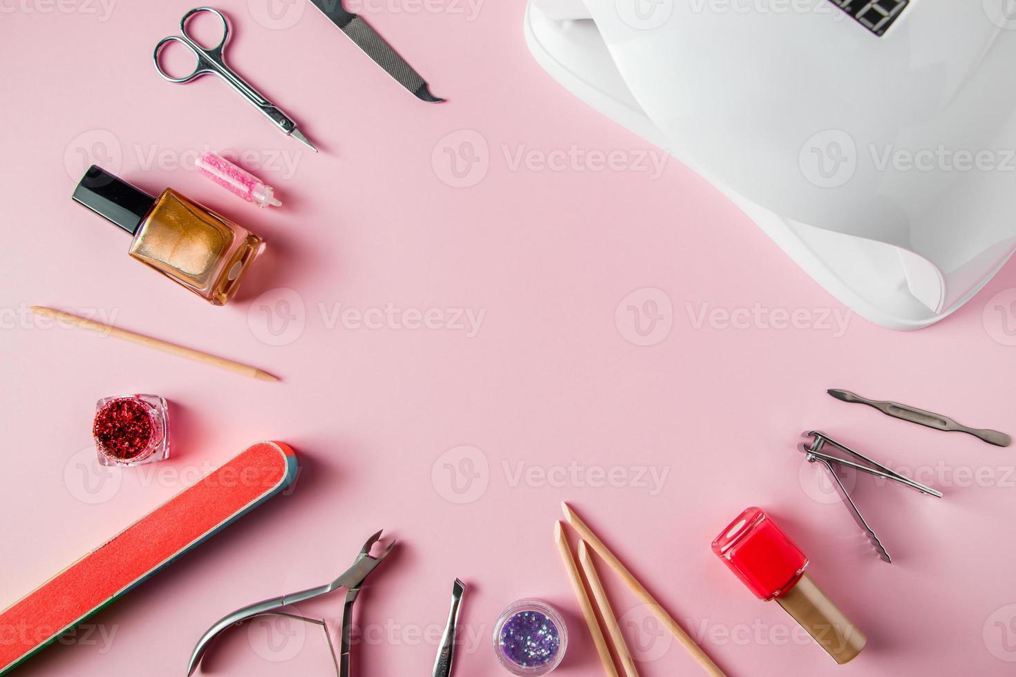 um conjunto de ferramentas para manicure e tratamento de unhas no local de trabalho com fundo rosa em um salão de beleza foto