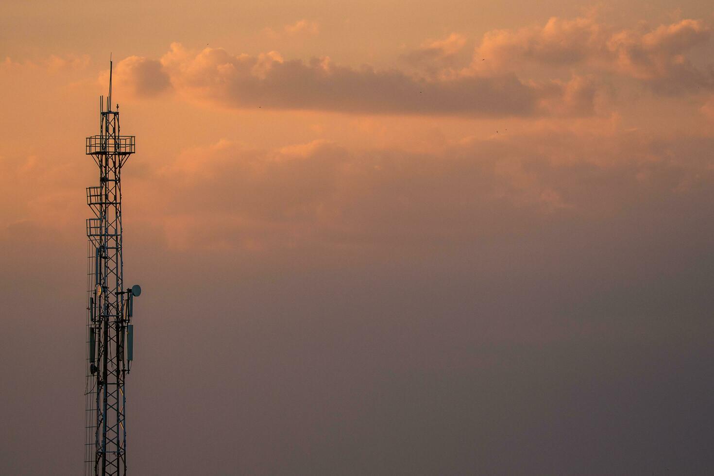 silhueta do torre debaixo nublado céu durante pôr do sol foto