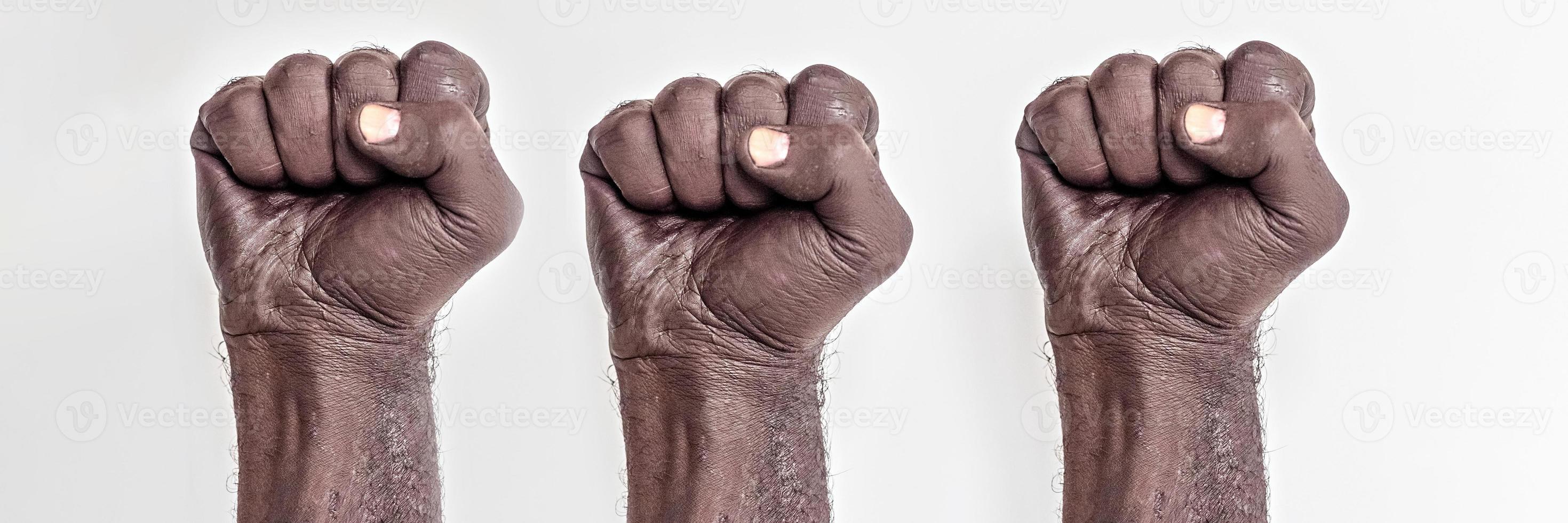 mãos masculinas cerradas em punho sobre um fundo branco. um símbolo da luta pelos direitos dos negros na américa. protesto contra racism.banner. foto