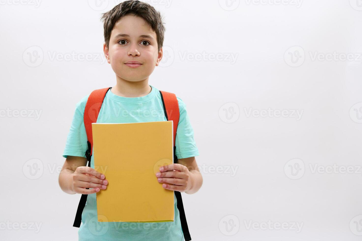 confiante caucasiano Adolescência garoto, feliz bonito escola criança com mochila, segurando pastas de trabalho, sorridente olhando às Câmera foto