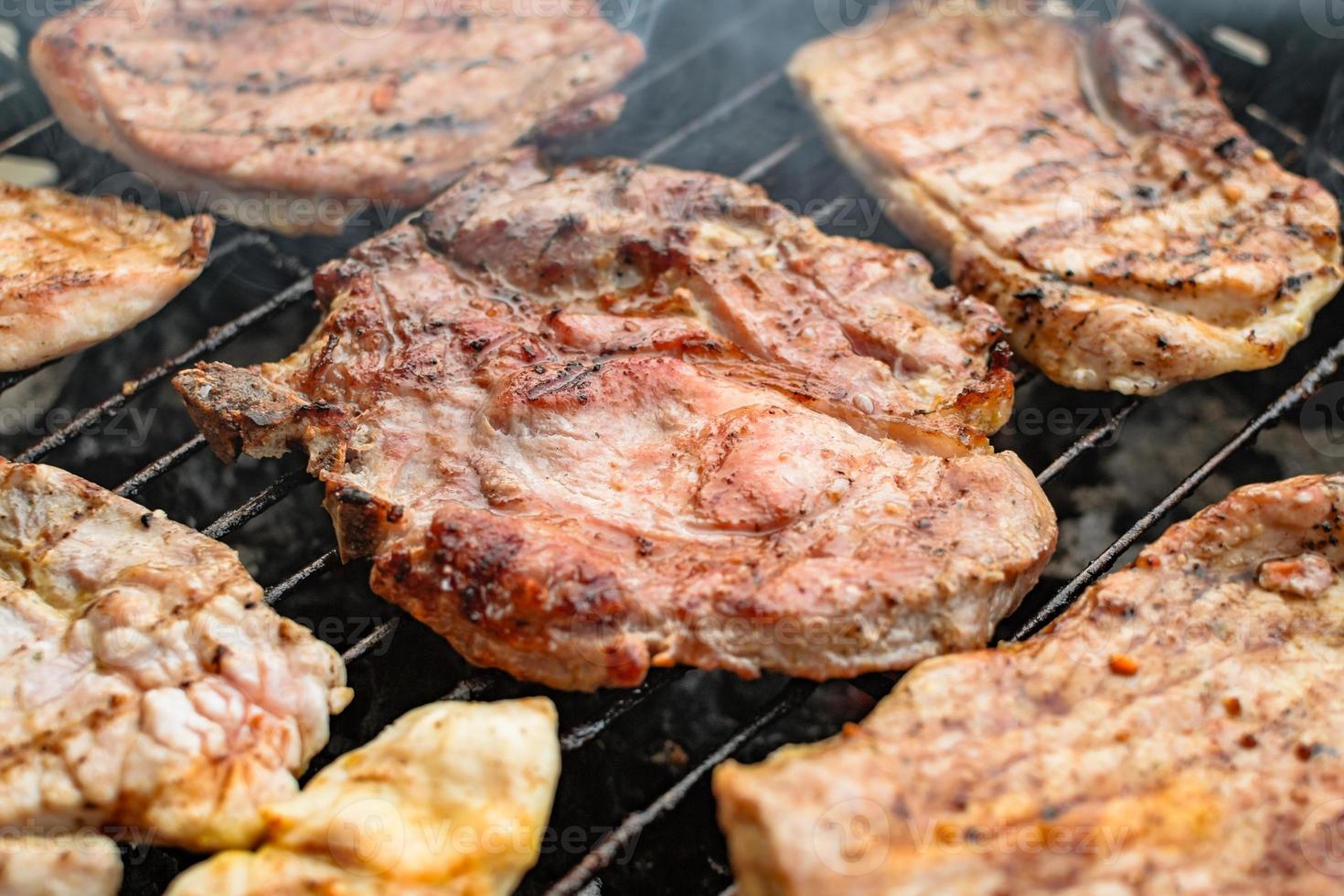 carnes grelhadas, carne de porco, vaca e frango na churrasqueira, grelha. profundidade superficial de campo. foto