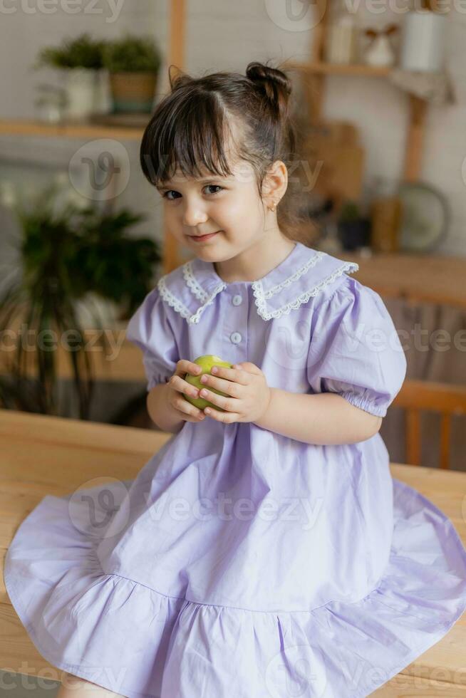 uma pequeno lindo menina dentro uma brilhante vestir é enganar por aí dentro a cozinha foto