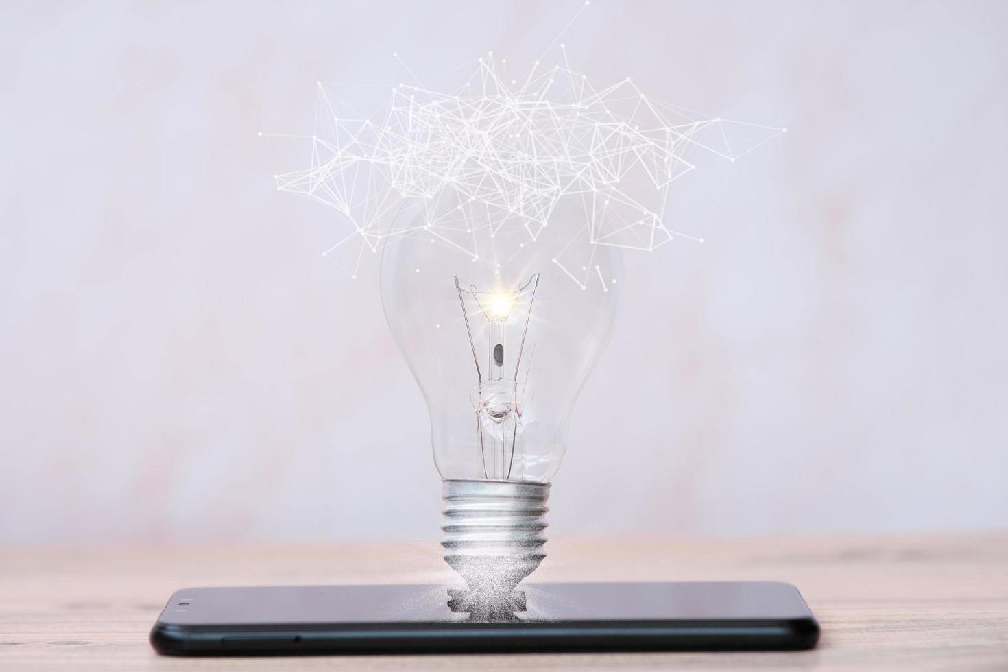 lâmpada economizadora de energia na mesa e conceito de crescimento de negócios e inovação de novas ideias foto