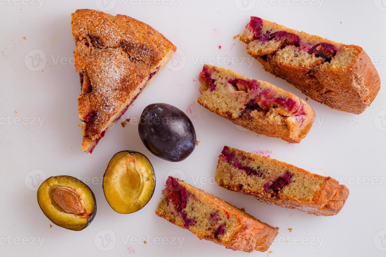 massa de ameixa cortada em pedaços, delicioso bolo de ameixa em quadro branco com decoração de ameixas frescas. foto