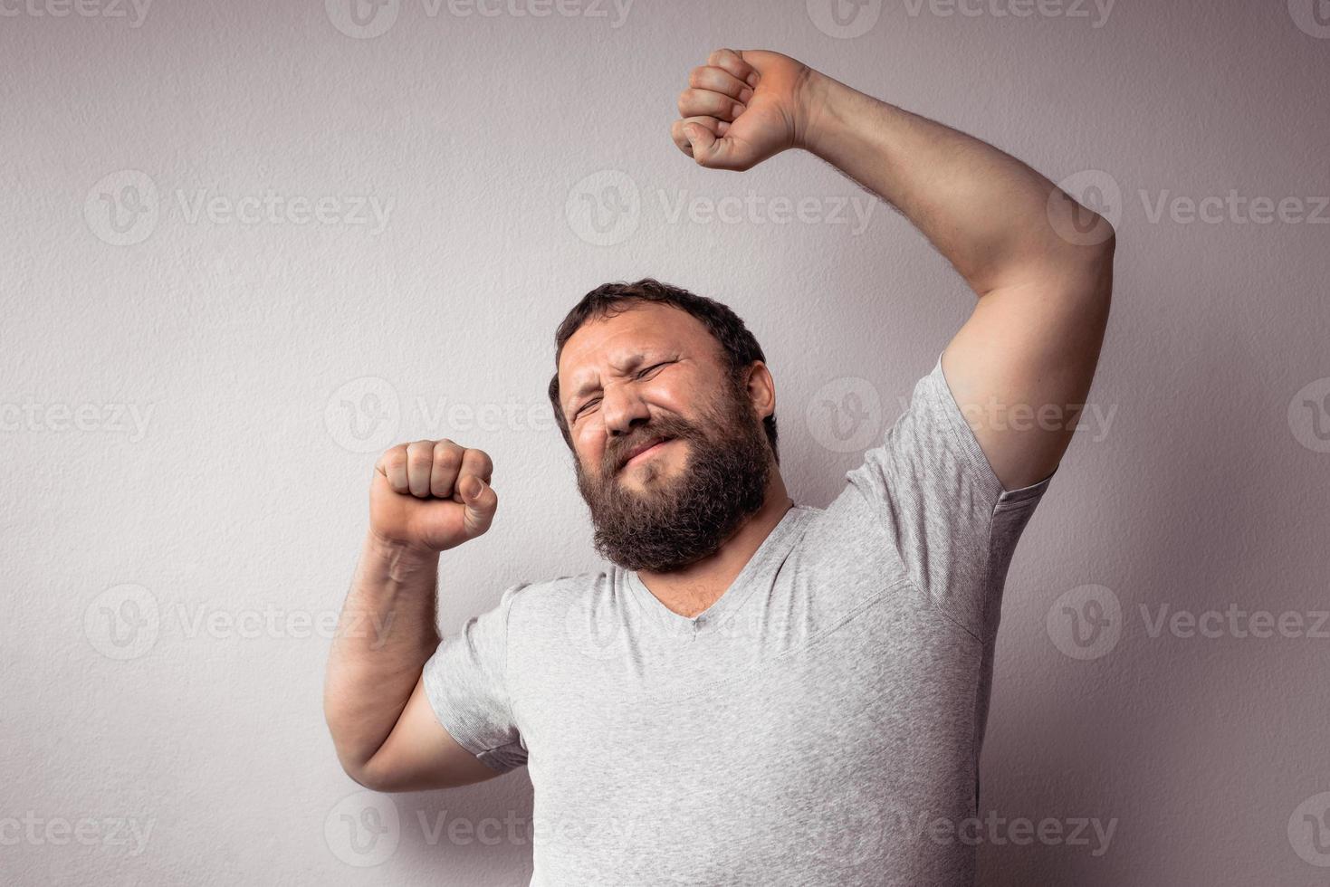 homem barbudo com camiseta cinza sentindo dores nas costas foto