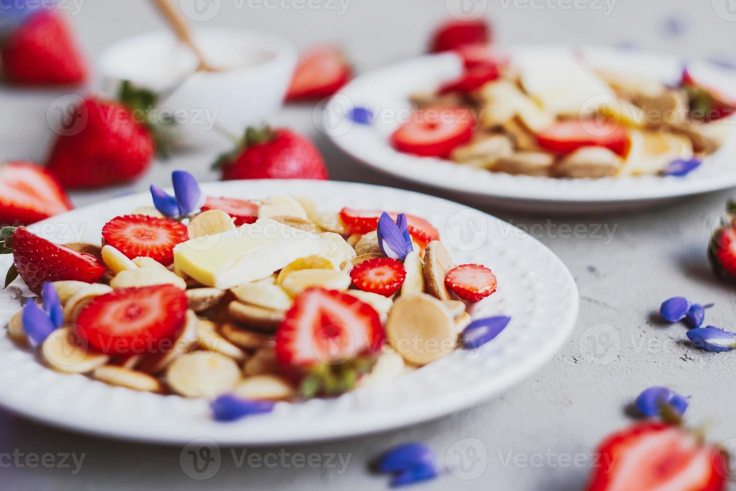 Cereais para panqueca, comida da moda. mini panquecas de cereais com manteiga, mel e morangos. foto