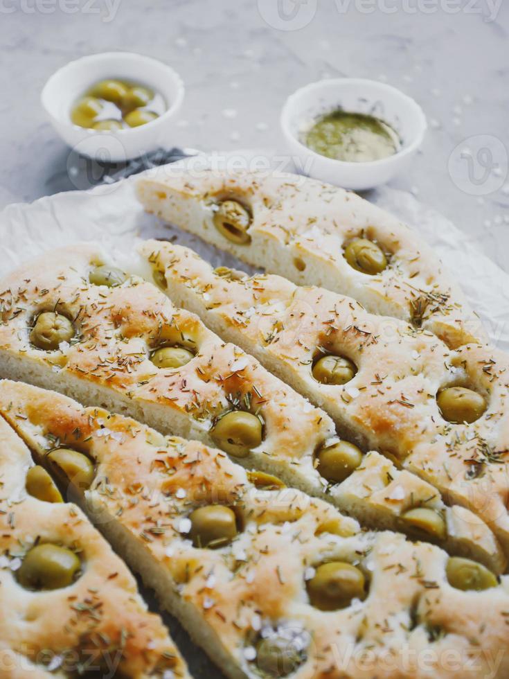 Pão de focaccia tradicional italiana com azeitonas, alecrim, sal e azeite. focaccia caseira. foto