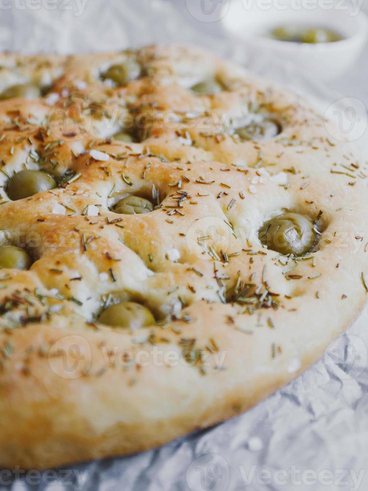 Pão de focaccia tradicional italiana com azeitonas, alecrim, sal e azeite. focaccia caseira. foto