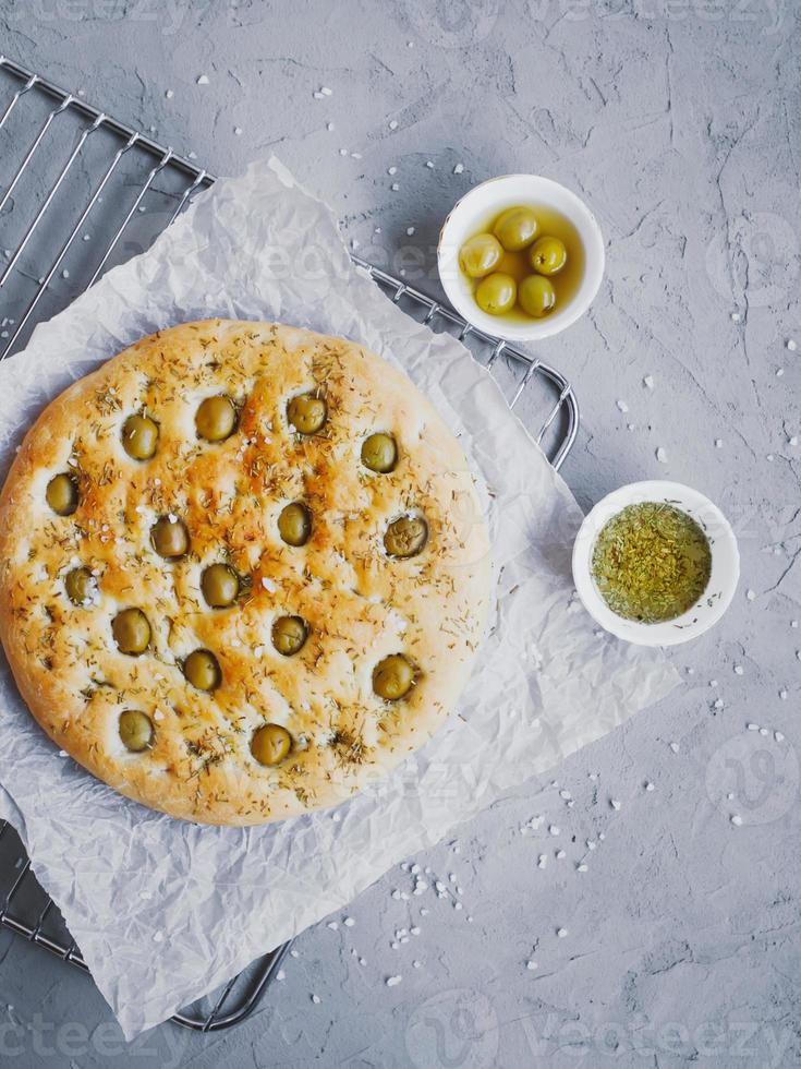 Pão de focaccia tradicional italiana com azeitonas, alecrim, sal e azeite. focaccia caseira. foto