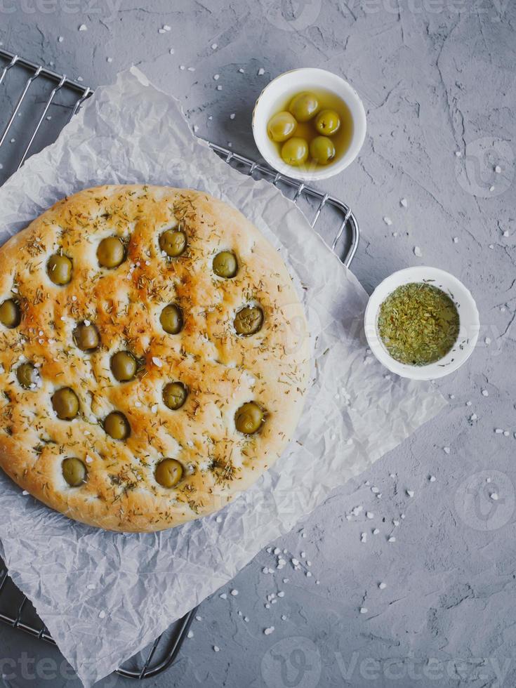 Pão de focaccia tradicional italiana com azeitonas, alecrim, sal e azeite. focaccia caseira. foto