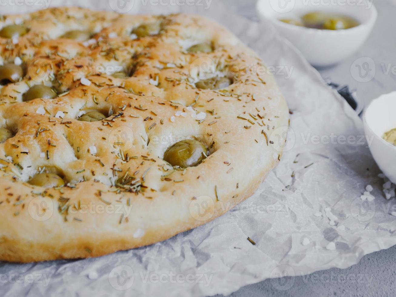 Pão de focaccia tradicional italiana com azeitonas, alecrim, sal e azeite. focaccia caseira. foto