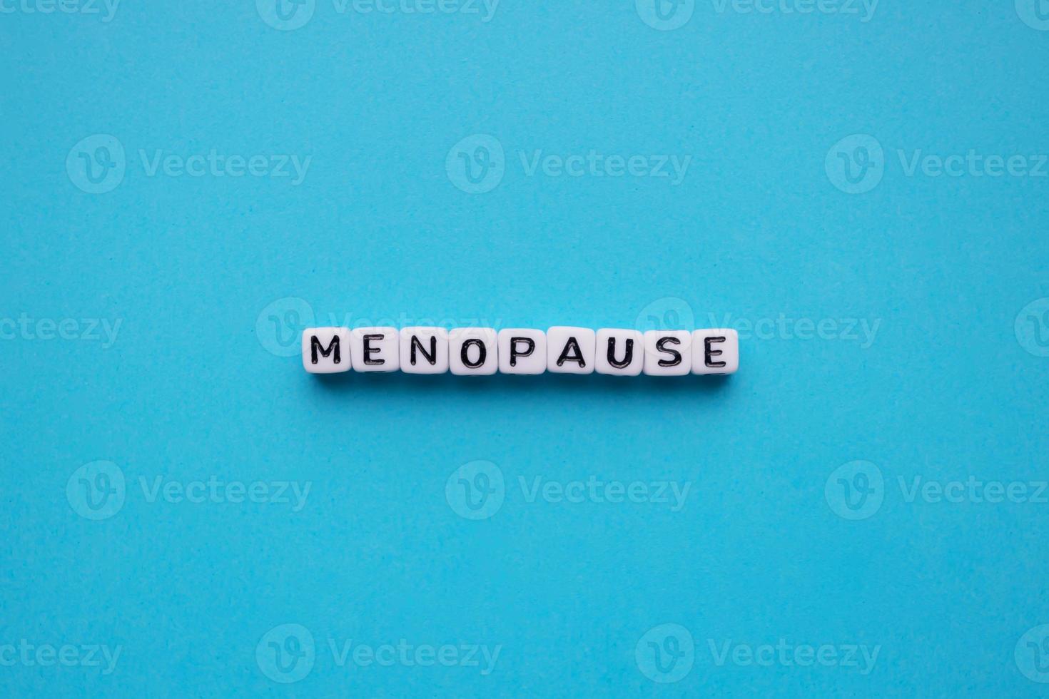 cubos de palavras da menopausa em um fundo azul foto