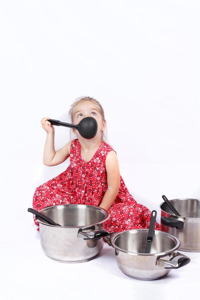 criança usando acessórios de cozinha se divertindo foto