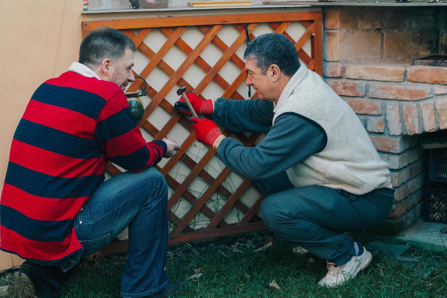 jovem adulto maduro ajudando homem idoso com trabalho de jardinagem foto