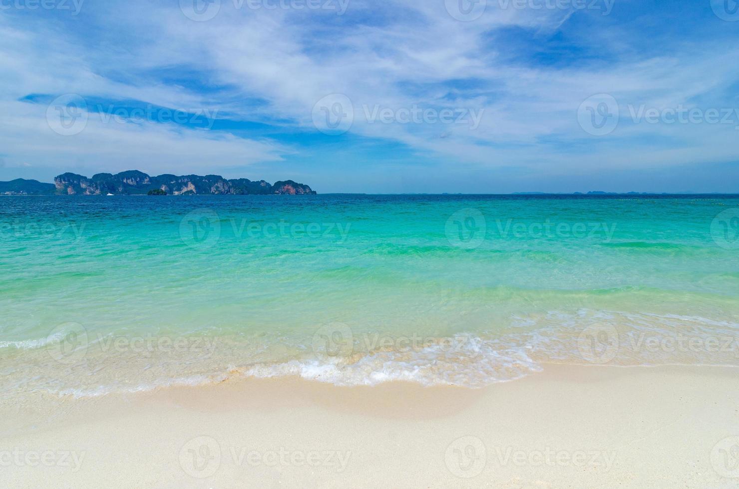 praia branca em um céu azul claro, mar azul foto