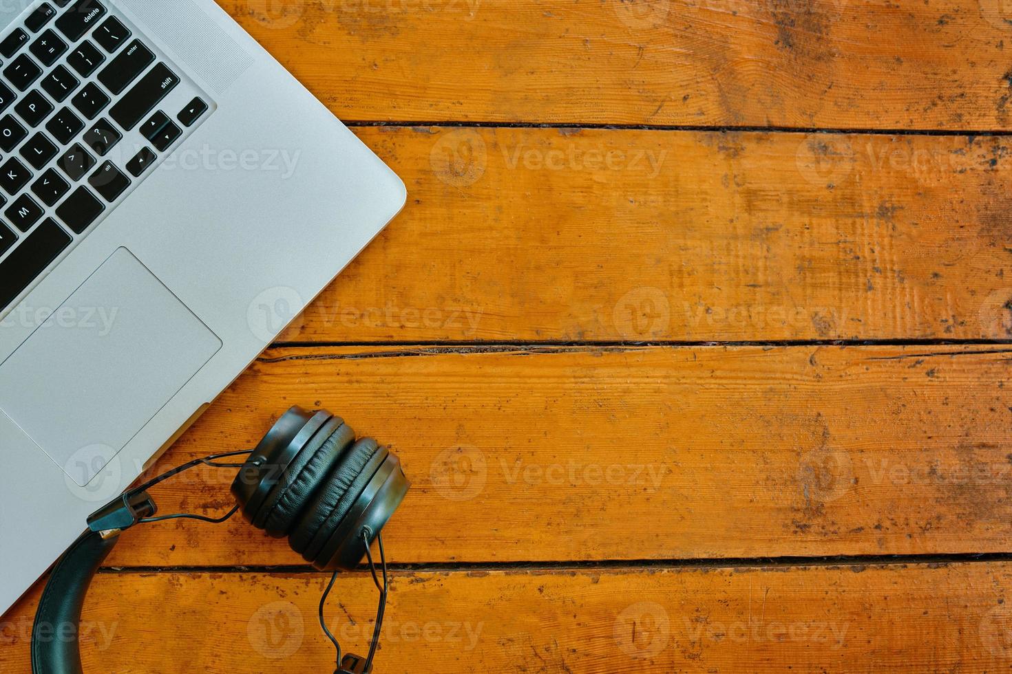 laptop e fones de ouvido sem fio na mesa de madeira. foto