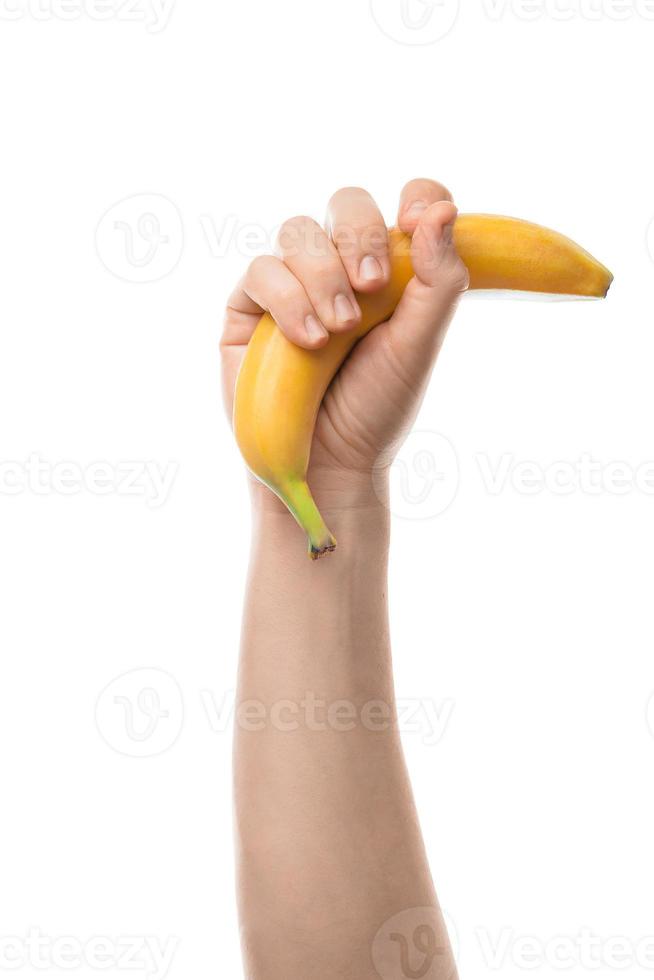 mão masculina segurando banana. isolado no fundo branco. foto