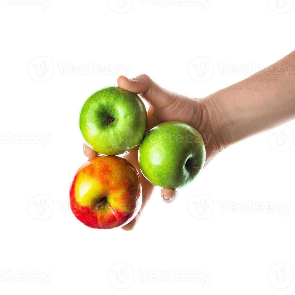 homem segurando um monte de maçãs vermelhas e verdes na mão. isolado no fundo branco. foto
