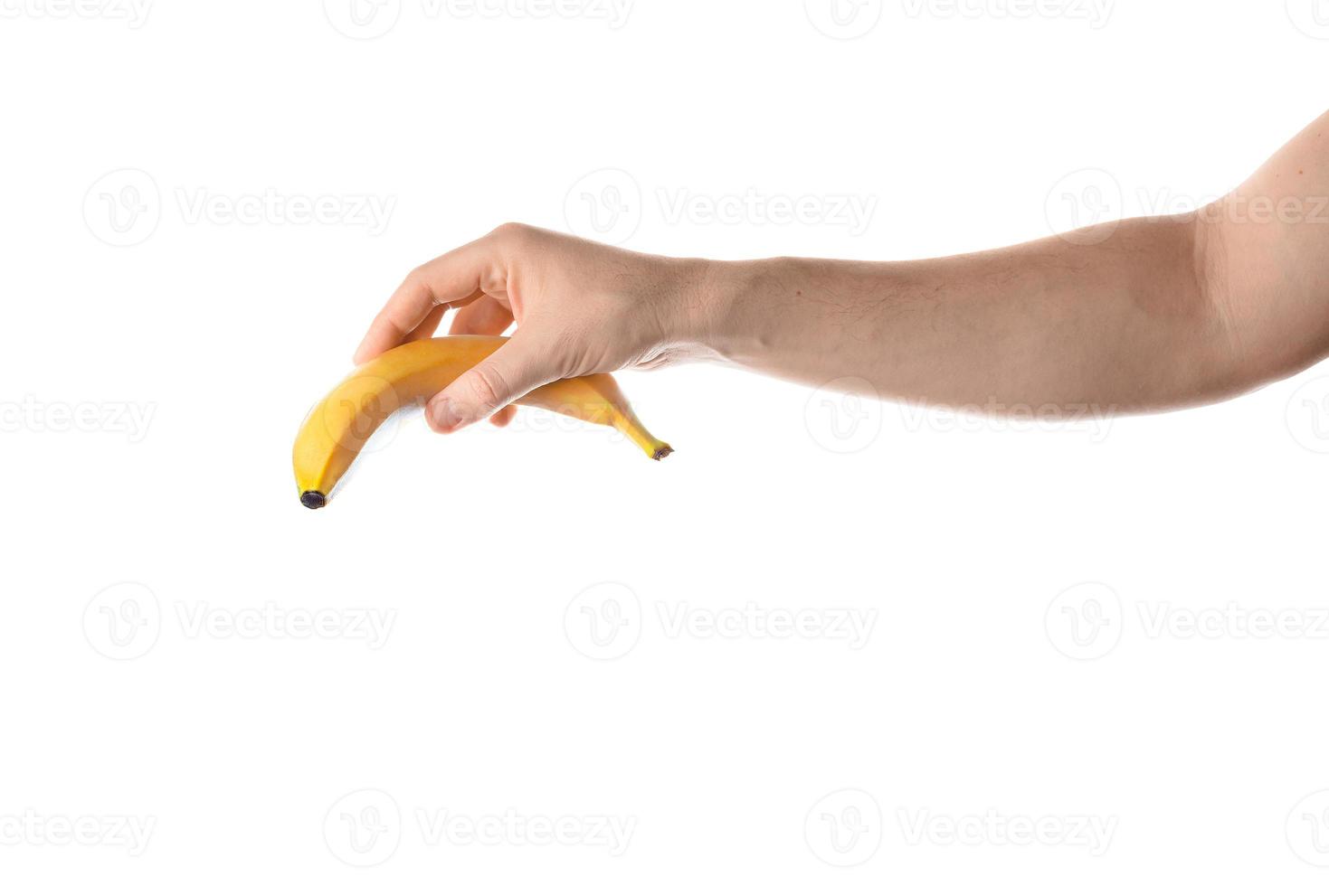 mão masculina segurando banana. isolado no fundo branco. foto