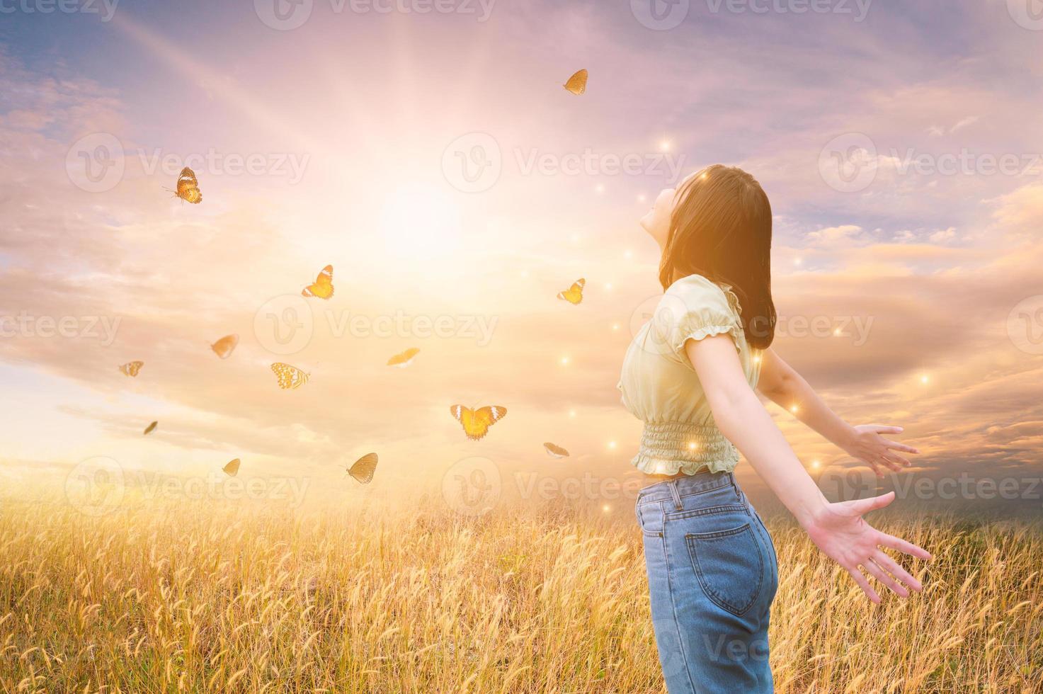 liberdade e saúde uma menina esticando os braços ao sol entre as borboletas foto