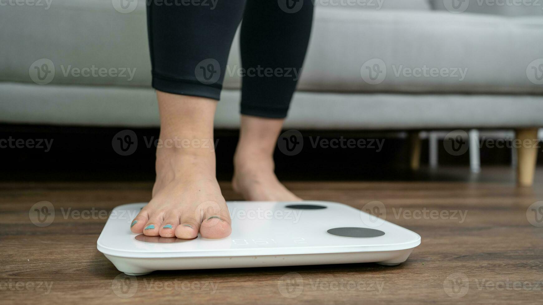 gordo dieta e escala pés em pé em eletrônico balanças para peso ao controle. medição instrumento dentro quilograma para uma dieta ao controle. foto