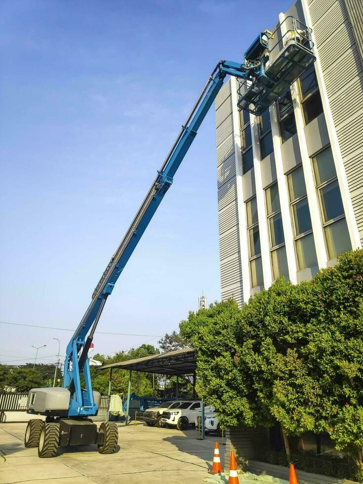 guindaste manlift com plataforma de elevação ao topo do telhado de um edifício foto