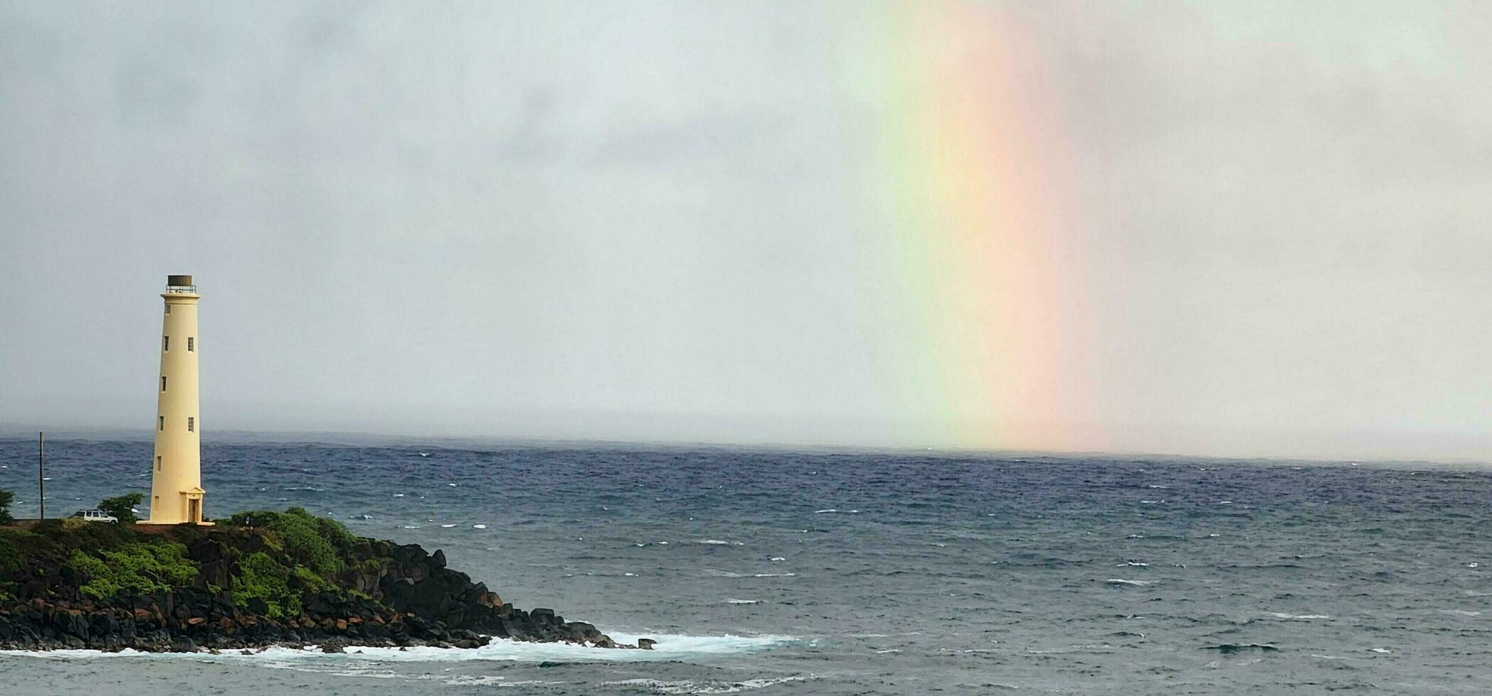 luz casa em a pacífico oceano com uma arco Iris dentro a fundo foto