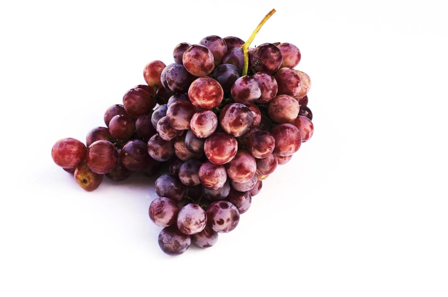 frutos de uva vermelha isolados no fundo branco foto