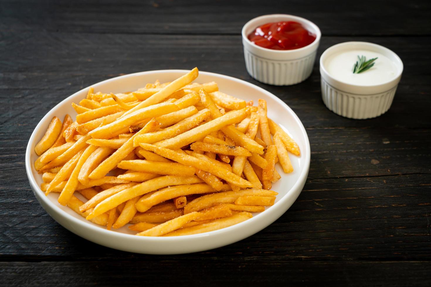 batatas fritas com creme de leite e ketchup foto