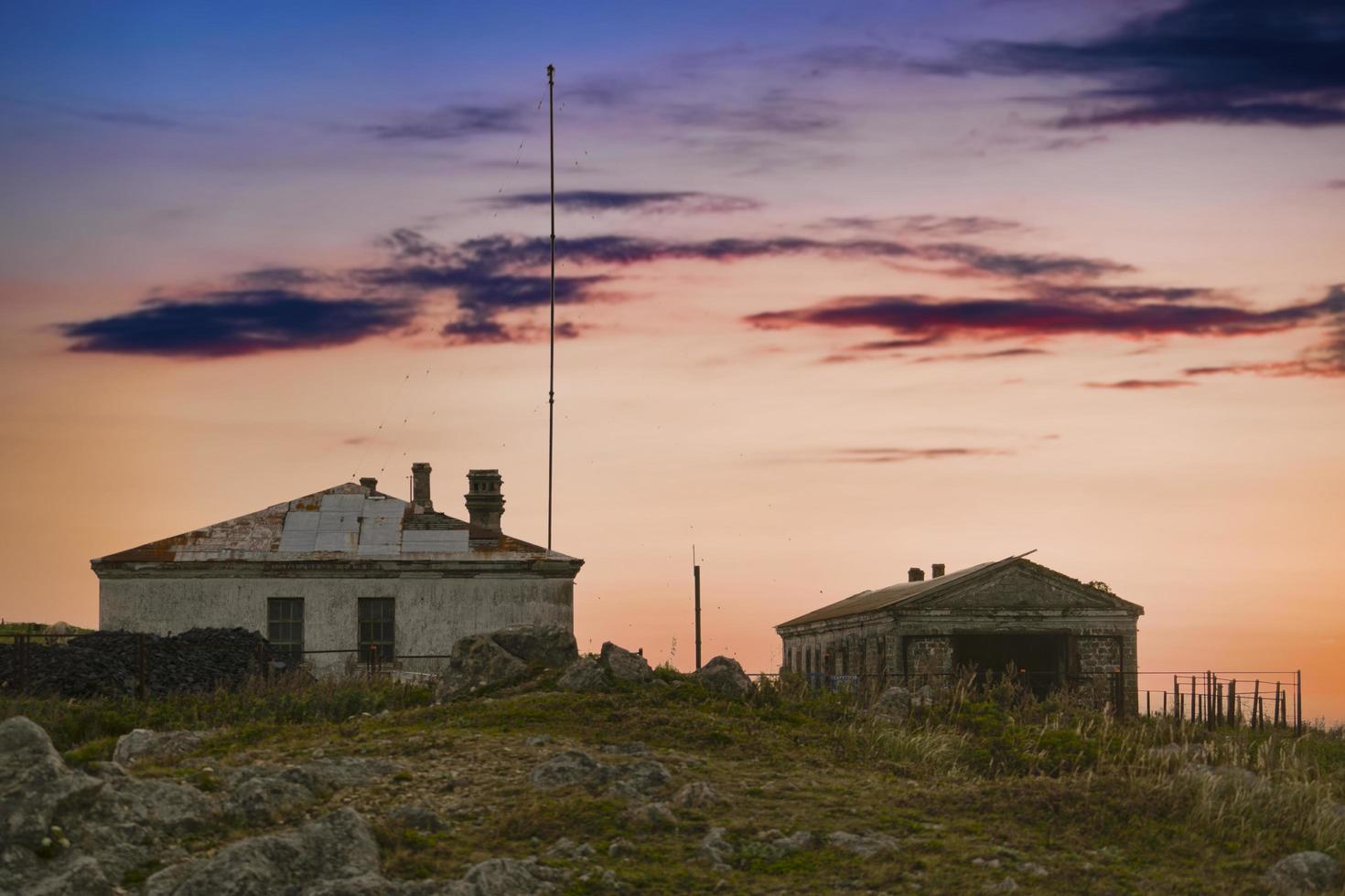 velhos edifícios abandonados no fundo do pôr do sol foto