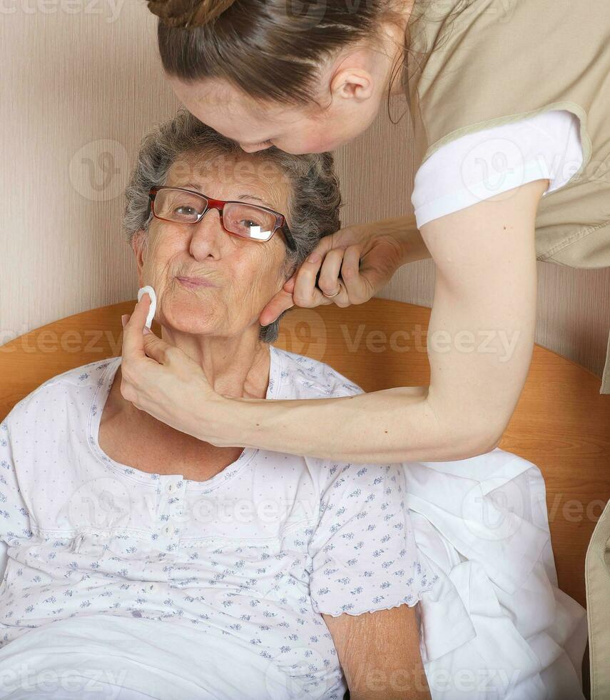 jovem social trabalhos assistente e Senior mulher dentro dela quarto foto