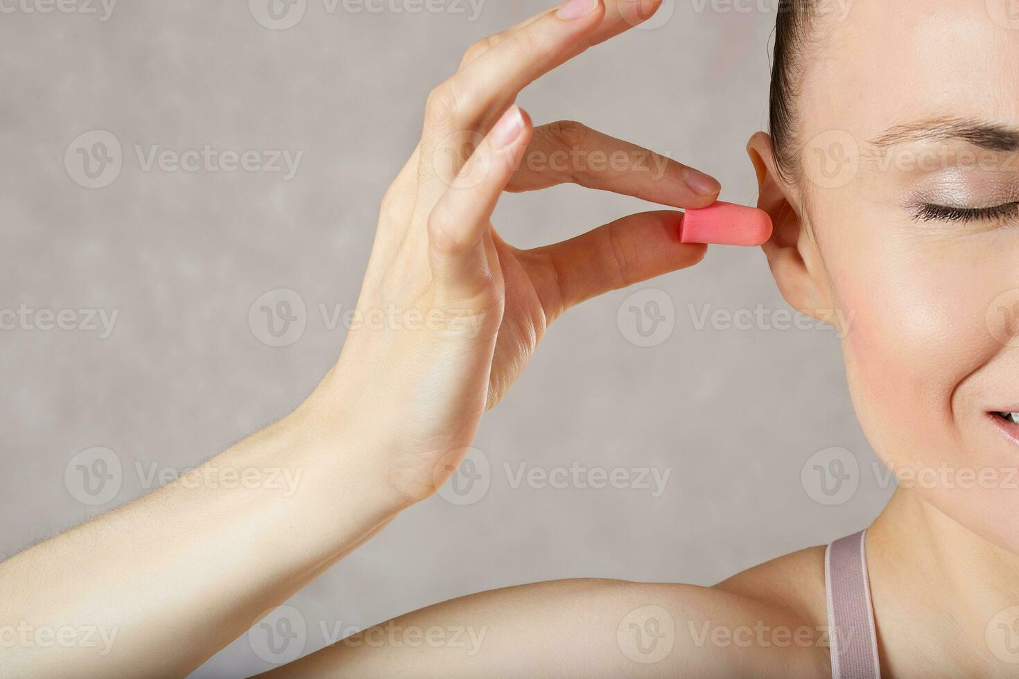 jovem mulher é apresentando tampões de ouvido. fechar-se. foto