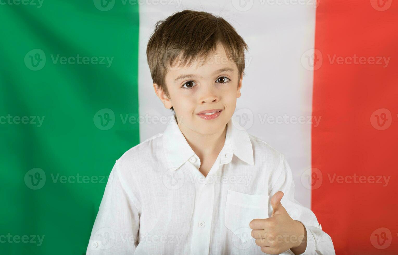 sorridente Garoto do Sete anos velho mantém uma livro.bandeira do Itália Como uma fundo. foto