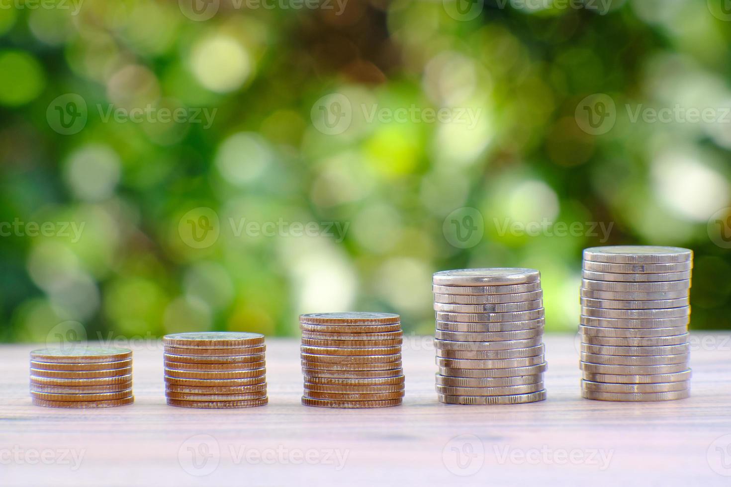 conceito de economia de dinheiro e empilhamento de moedas no fundo da mesa foto