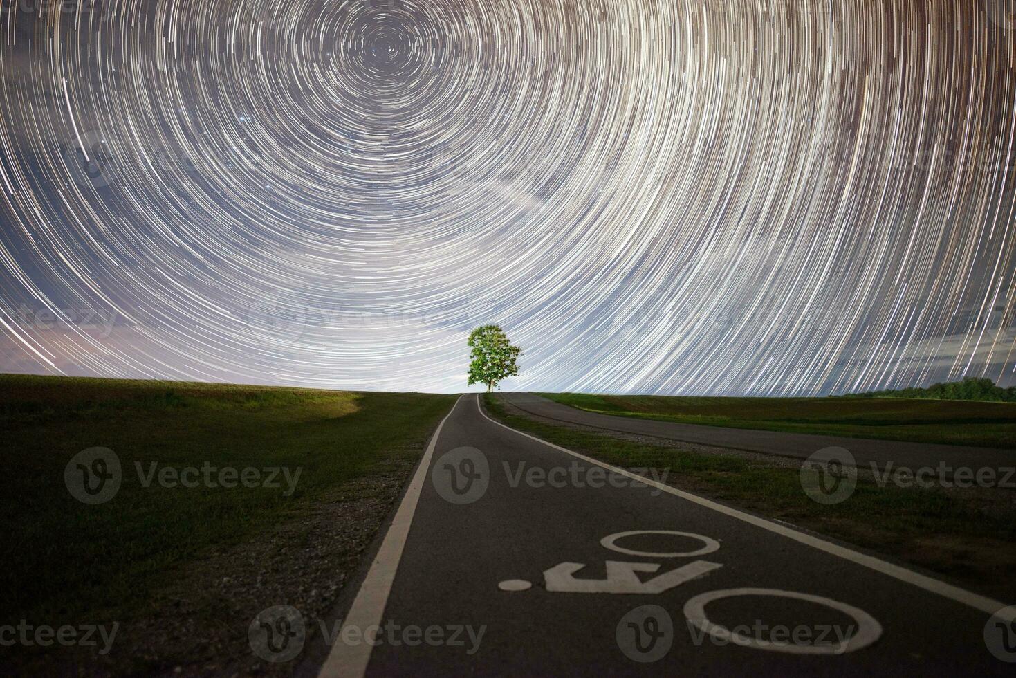 solitário árvore debaixo a lindo Estrela trilhas dentro a estrelado noite. foto