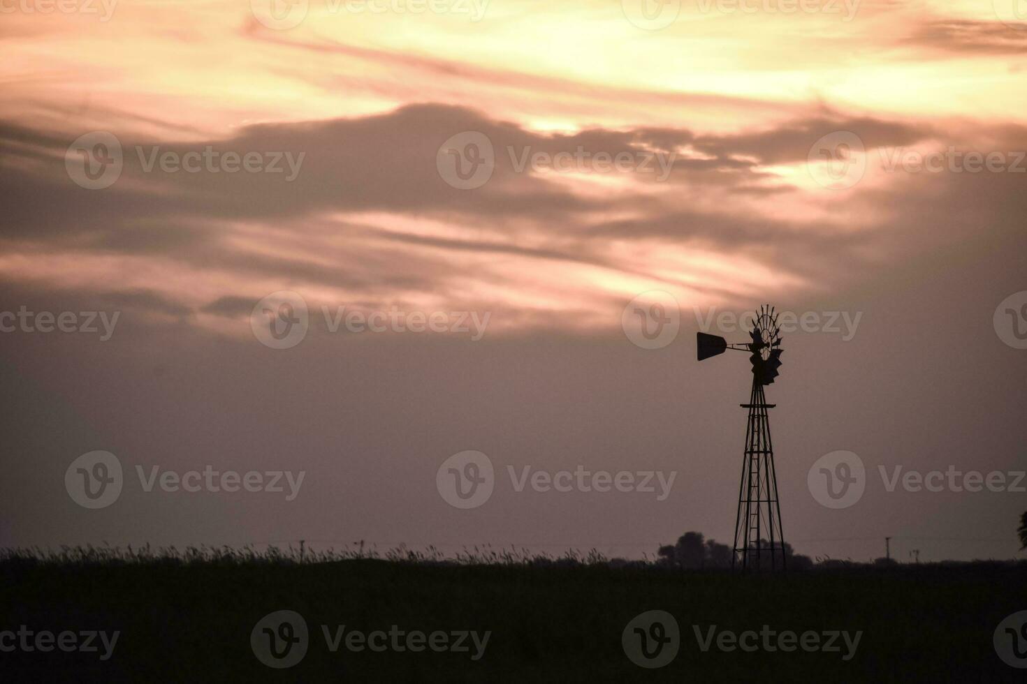 rural panorama com moinho de vento às pôr do sol, pampas , Argentina foto