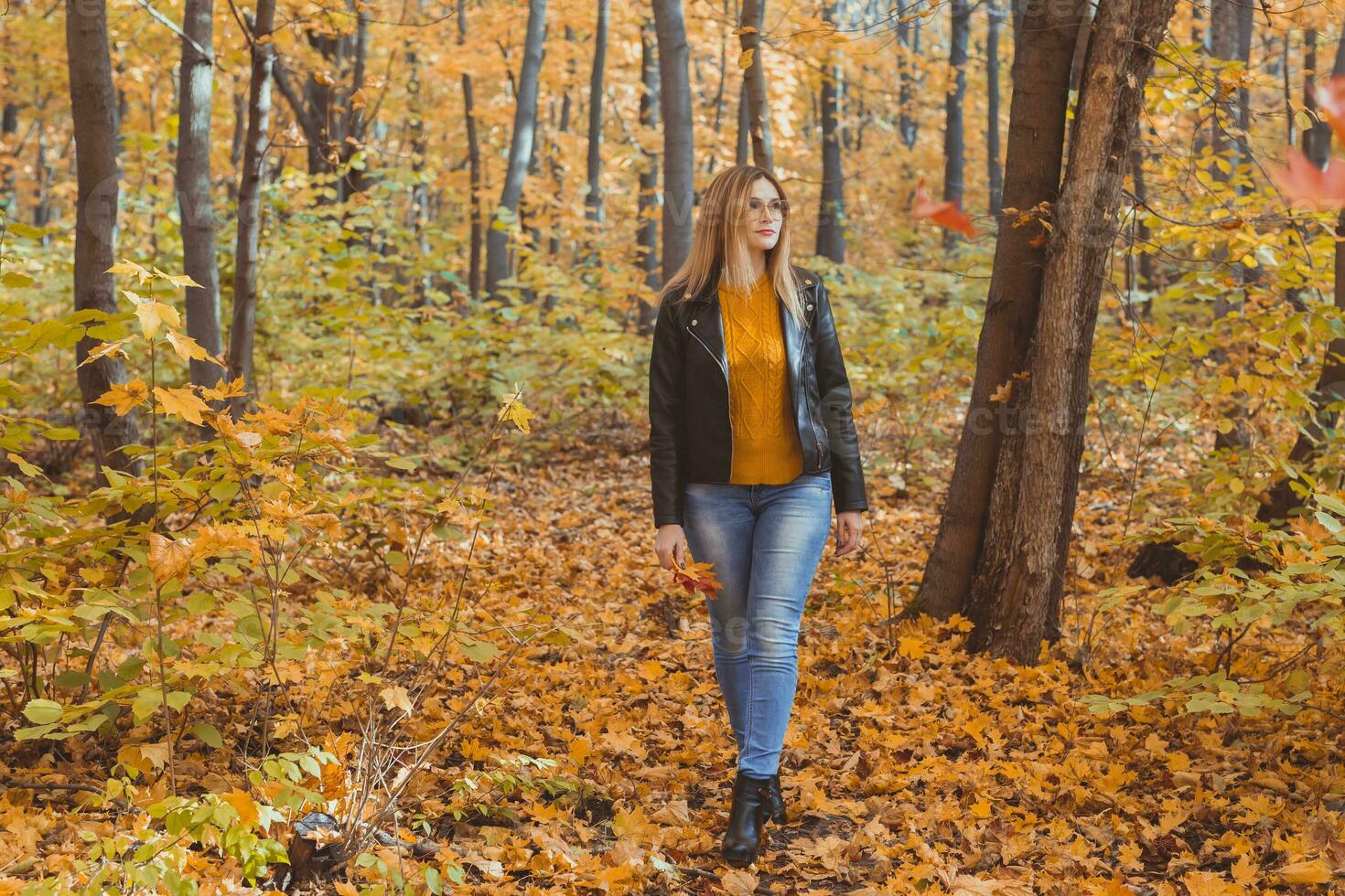 solitário triste mulher é chutando amarelo folhas dentro outono. triste humor e sazonal afetivo transtorno conceito. foto
