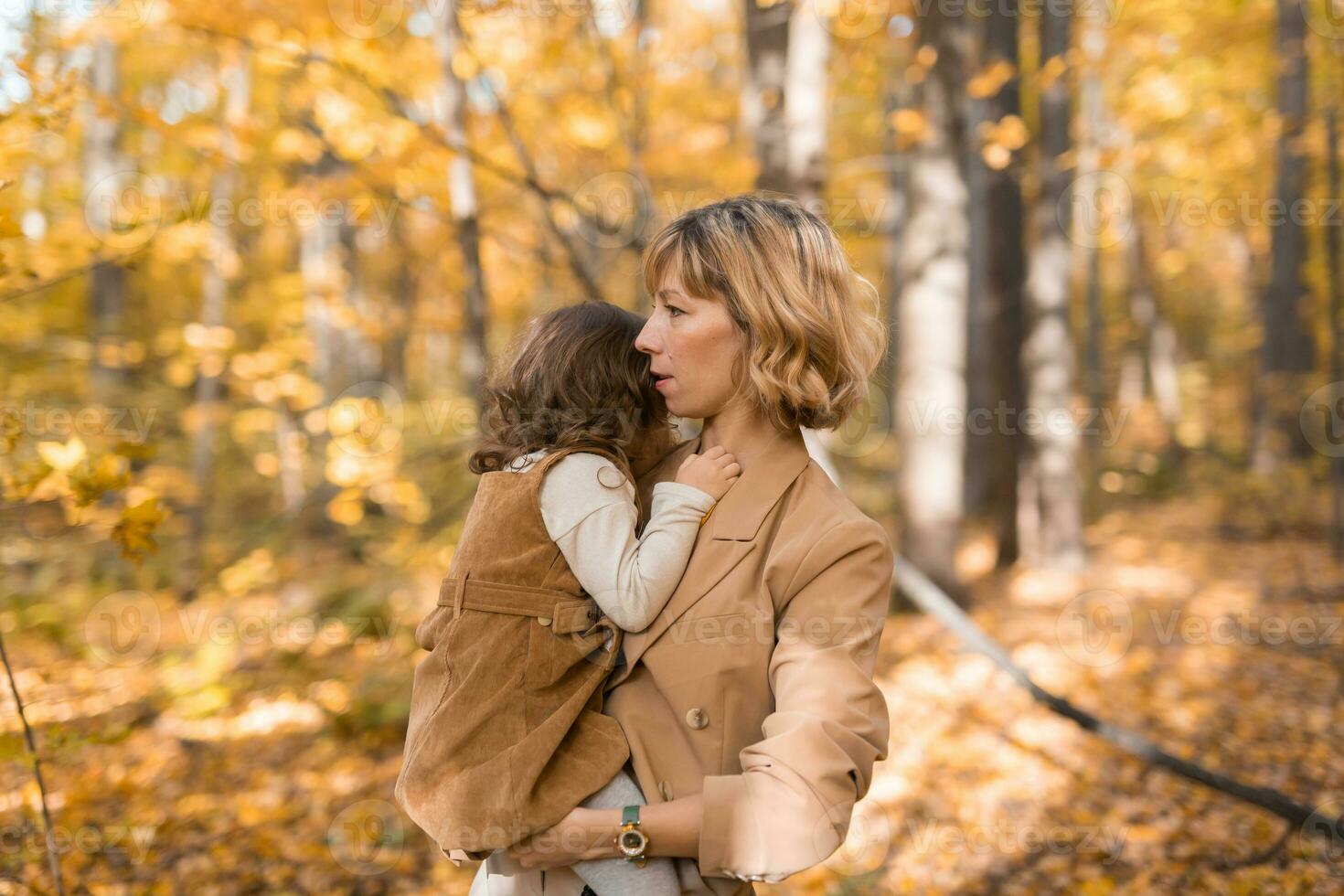 mãe com criança dentro dela braços contra fundo do outono natureza. família e estação conceito. foto