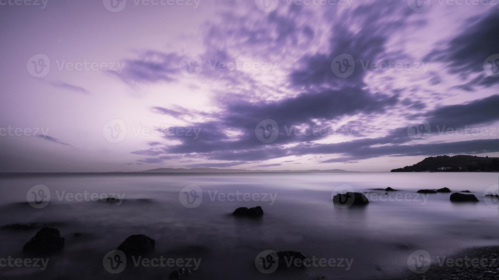 paisagem de areia e costões rochosos. bela vista do mar nublado ao pôr do sol e movimento turva água, kassandra, Grécia. foto