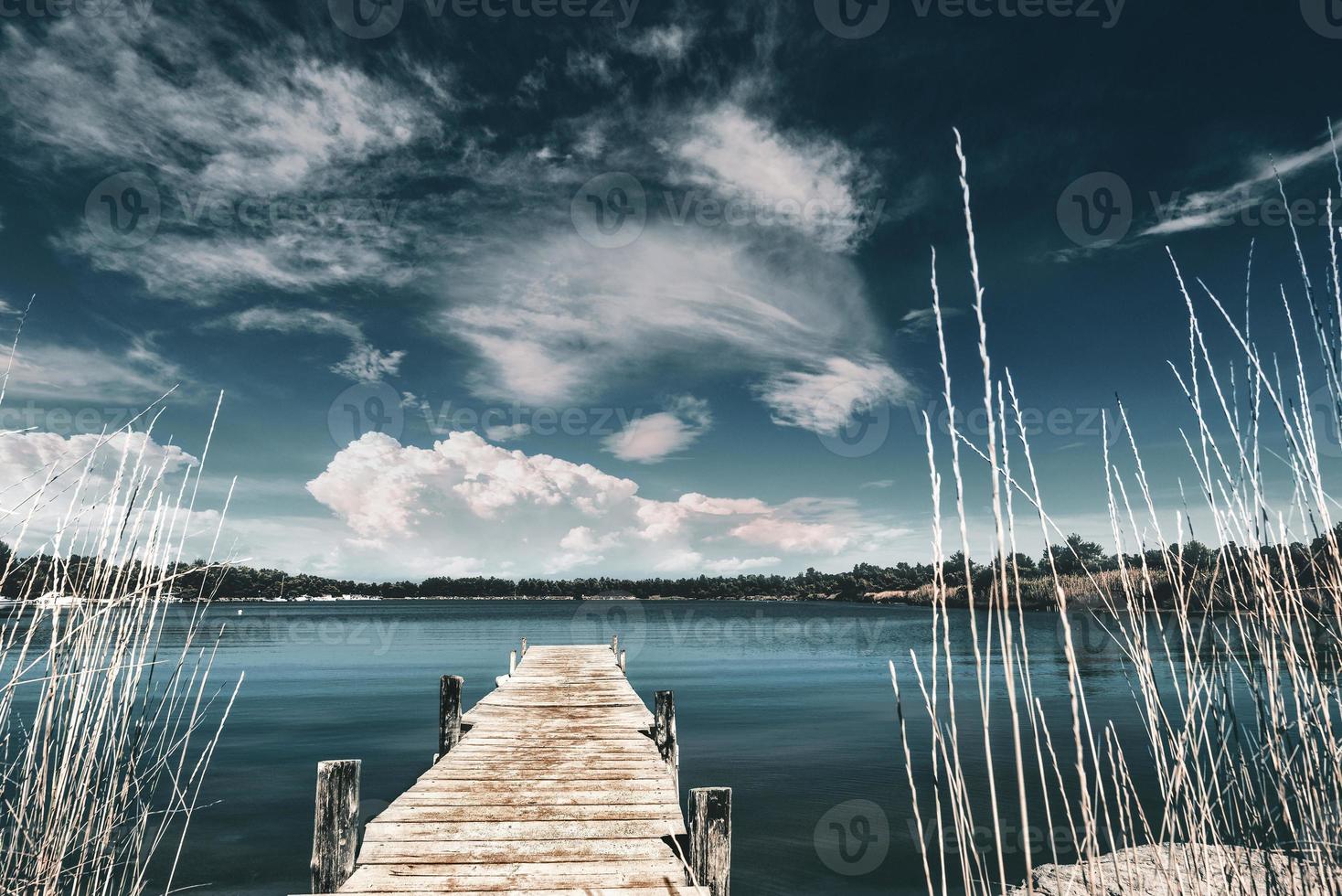 píer de madeira com fundo azul do mar e do céu, o píer de madeira está localizado em um pequeno porto natural perto da praia da lagoa, península kassandra, grécia. foto